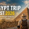 A traveler stands before the Great Pyramids of Giza and the Sphinx at sunrise, overlooking one of Egypt's most iconic archaeological sites. Bold headline text reads "Egypt Trip Cost 2026: Complete Budget Guide for Every Traveler," highlighting a comprehensive guide to travel expenses, budgeting tips, and vacation planning for visitors to Egypt in 2026.