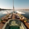 Nile River Cruise ship sailing past palm-fringed banks and desert hills between Luxor and Aswan