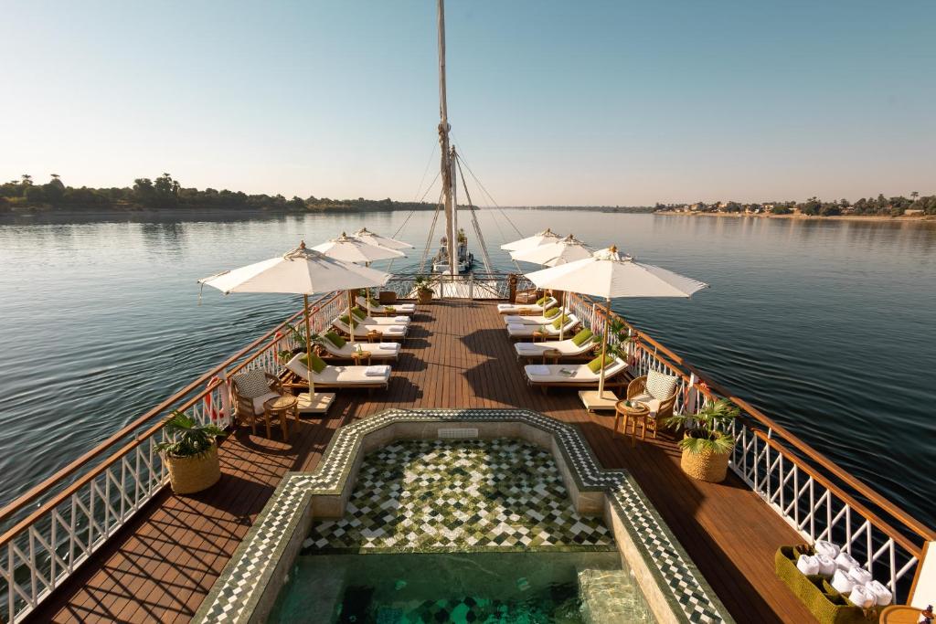 Nile River Cruise ship sailing past palm-fringed banks and desert hills between Luxor and Aswan