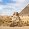 Within Egypt Tours a Wide panoramic view of the Giza Plateau showing the Great Sphinx in the foreground and the Pyramids of Khafre and Khufu rising behind it